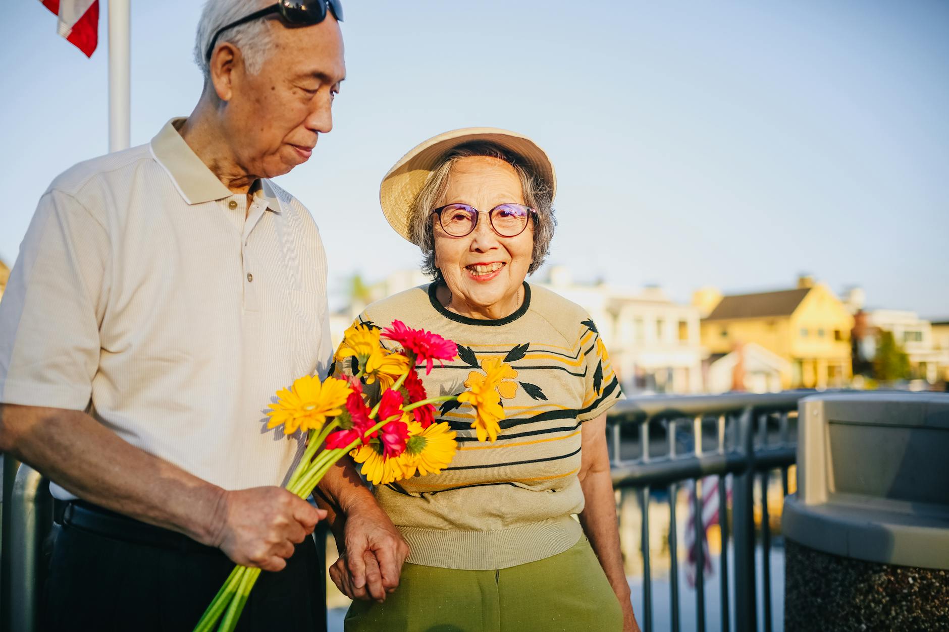 elderly couple holding hands and holding flowers