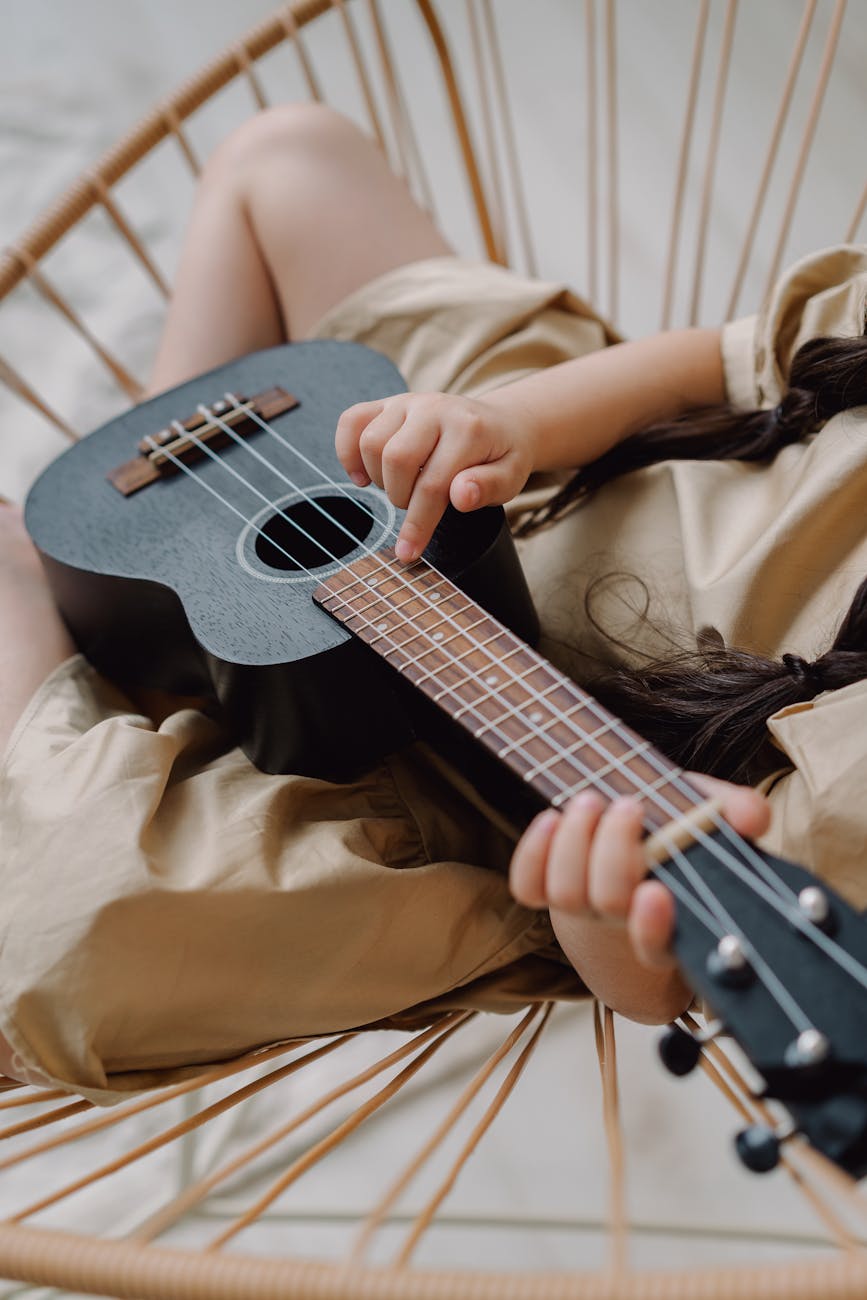close up shot of a person playing ukelele